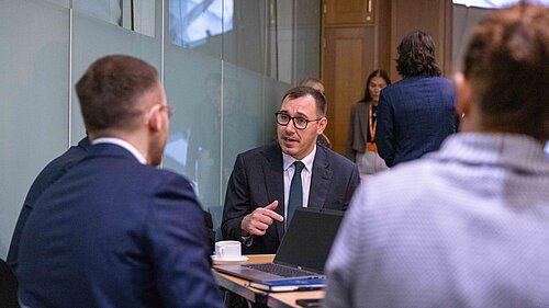 Tom Gordon sat round a table talking to a group of people