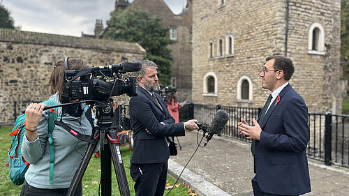 Tom Gordon stood speaking to the media on College Green near Parliament