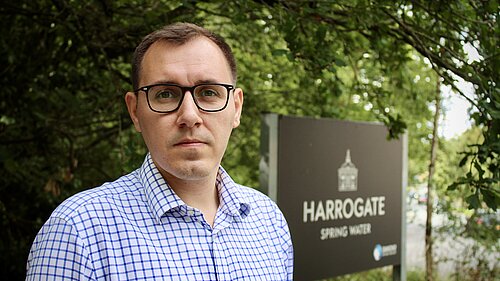 Tom Gordon MP stood by Harrogate Spring water sign