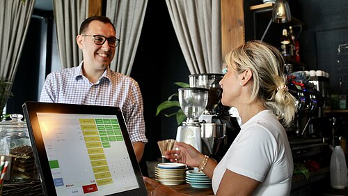 Tom Gordon MP talking to a cafe owner