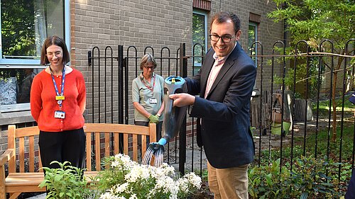 Tom Gordon watering plants on his visit to Harrogate Hospital and Community Charity