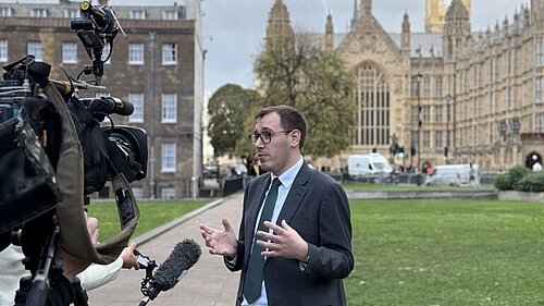 Tom Gordon stood outside Parliament talking to the media