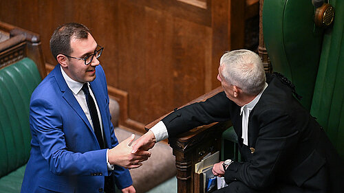 Tom shaking hands with speaker within commons