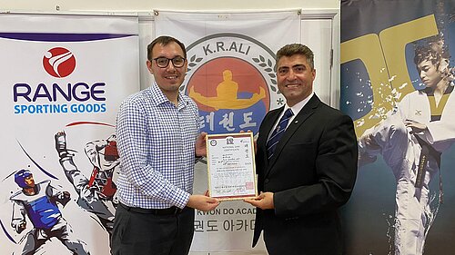 Tom Gordon MP receiving a certificate from Kambiz R. Ali Master 