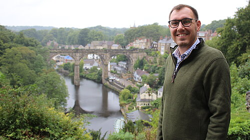 Tom Gordon MP standing near viaduct.