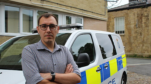 Tom Gordon MP in front of a police van