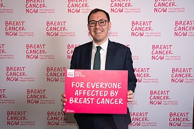 Tom Gordon MP holding a Breast Cancer support signer