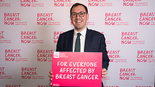 Tom Gordon MP holding a Breast Cancer support sign