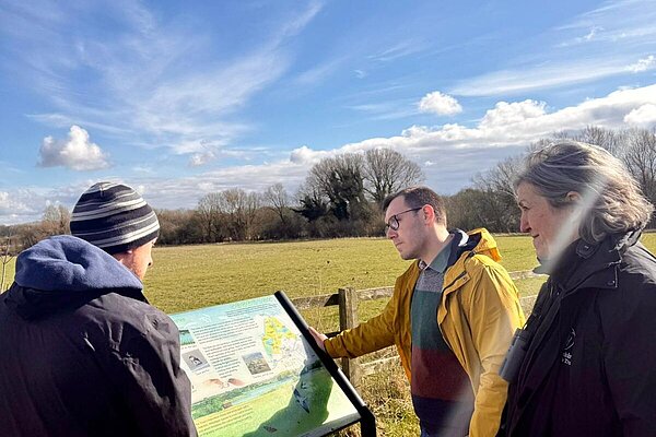 Tom Gordon stood looking at an information sign alongside representatives of Yorkshire Wildlife Trust