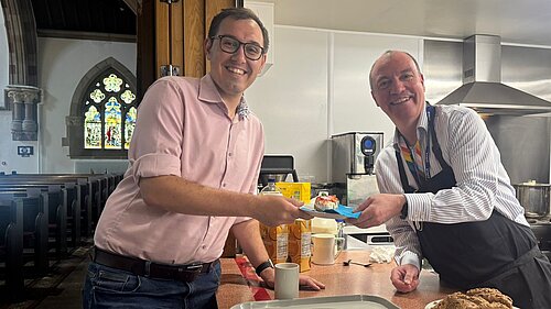 Tom being served a cup of tea by the CEO of the Harrogate Homeless Project
