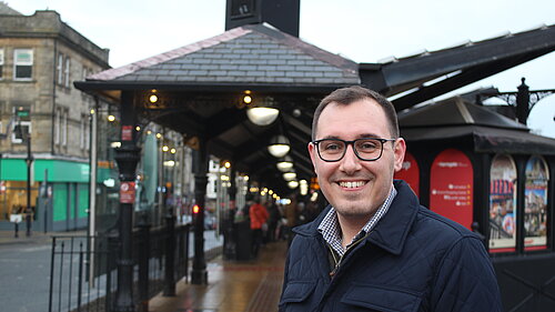 Tom stood in front of Harrogate bus station