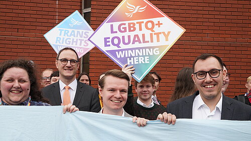 Tom Gordon stood outside the Harrogate Convention Centre with LGBTQ+ signs and other Liberal Democrats