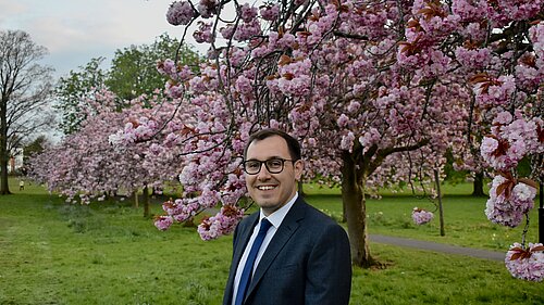 Tom Gordon stood on the Stray in front of blossoming trees