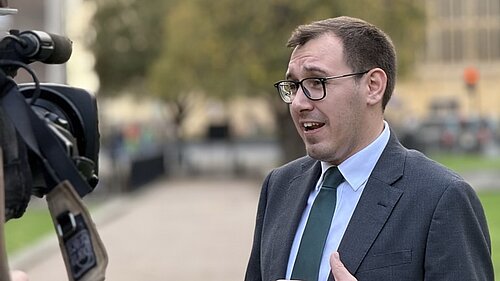 Tom being interviewed by the press, outside houses of parliament