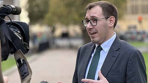 Tom Gordon stood in front of the Houses of Parliament